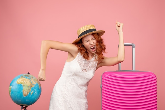 Free Photo front view of young female tourist with pink bag rejoicing on pink wall