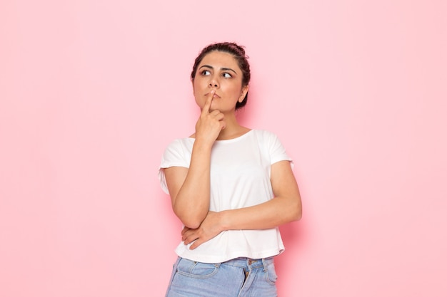 A front view young female in white t-shirt and blue jeans daydreaming and thinking