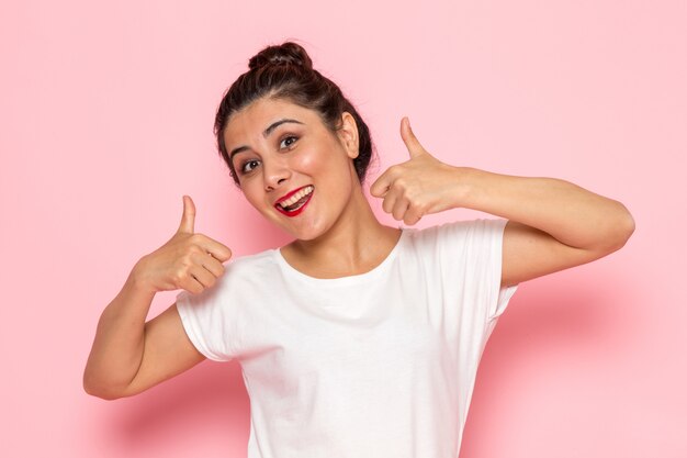 A front view young female in white t-shirt and blue jeans posing with emotional expression