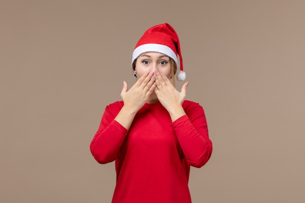 Front view of young female with christmas cape on brown