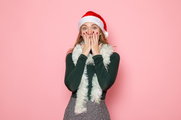 Free photo front view of young female with garlands surprised on pink wall