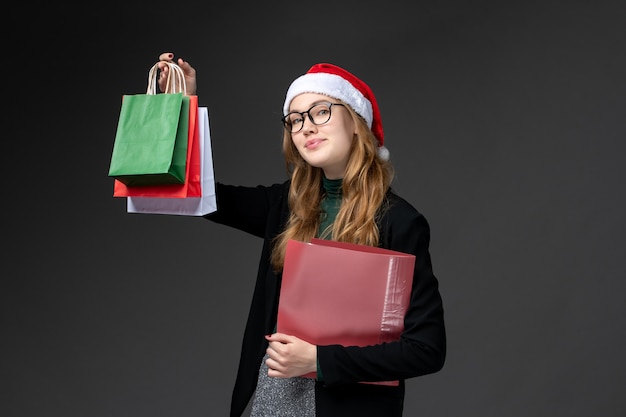 Front view young female with packages on dark wall gift new year christmas present