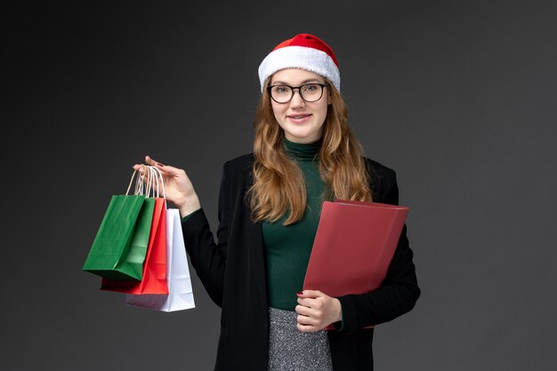 Front view young female with packages on dark wall gifts new year christmas present