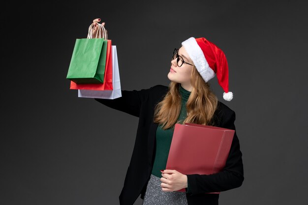 Front view young female with packages on dark wall gifts new year christmas