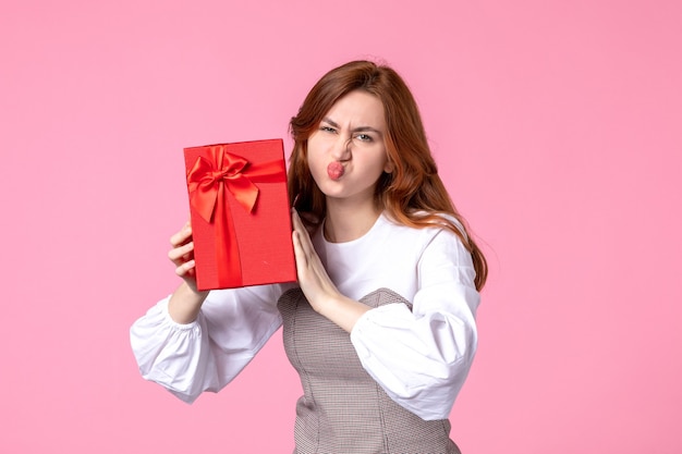 Front view young female with present in red package on pink background love date march horizontal sensual gifts perfume equality woman photo money