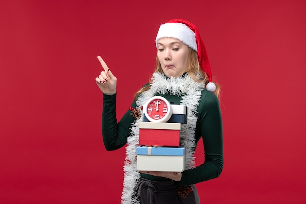 Front view young female with presents with clock on a red background