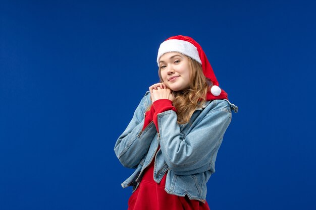 Front view young female with red christmas cap on blue background emotions christmas holiday