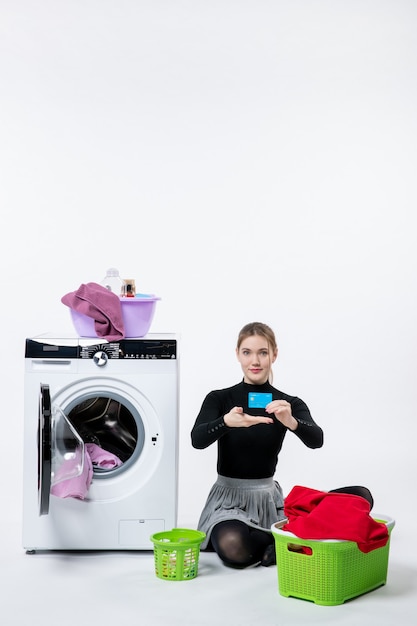 Free photo front view of young female with washing machine holding bank card on a white wall