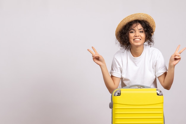 Front view young female with yellow bag preparing for trip on a white background color flight rest voyage plane tourist vacation