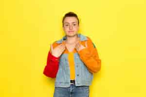 Free photo a front view young female in yellow shirt colorful jacket and blue jeans posing