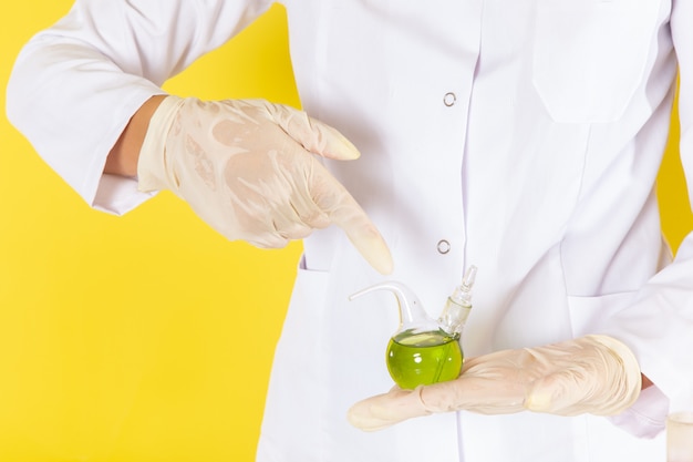 Free photo front view of young feman chemist in white suit working with chemical solutions