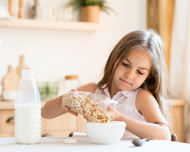 Free photo front view of young girl eating cereals