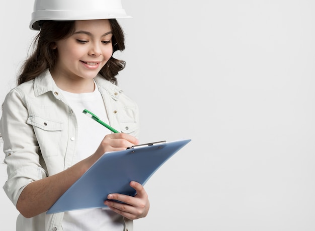 Free photo front view young girl holding clipboard