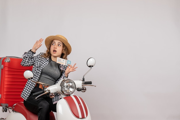 Front view young girl on moped holding up ticket