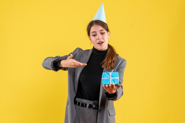 Front view young girl with party cap holding her gift