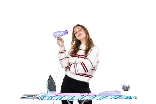 Free Photo front view young housewife holding hairdryer on white