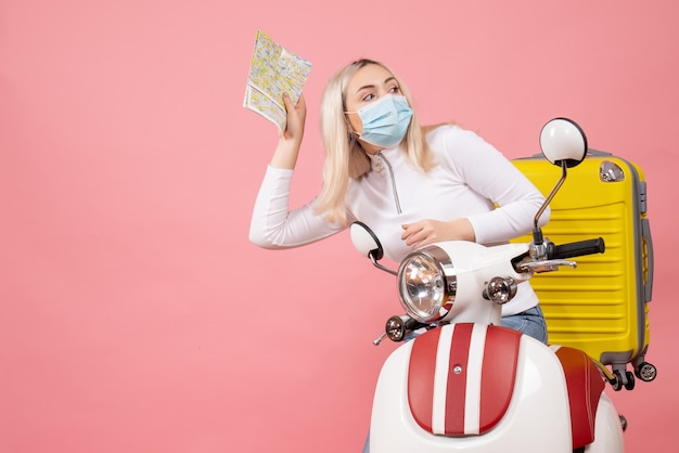 Free photo front view young lady on moped with yellow suitcase holding map