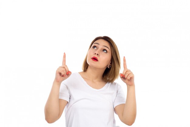 A front view young lady in white t-shirt posing looking into the skies on the white