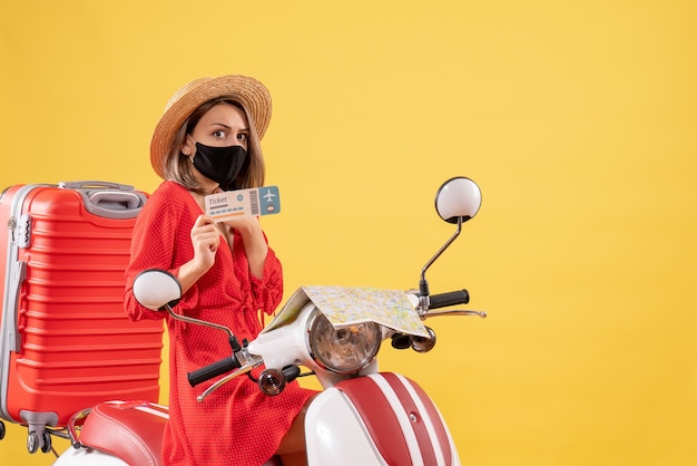 Free Photo front view young lady with black mask on moped holding up ticket