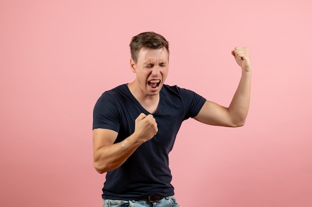 Free photo front view young male in dark-blue shirt emotionally rejoicing on pink background man model emotion male human color