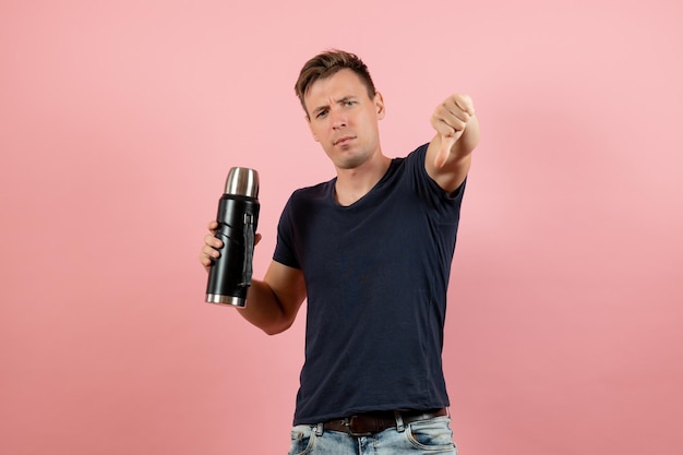 Front view young male in dark-blue shirt posing on pink background