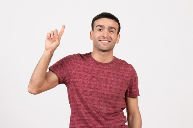 Front view young male in dark-red t-shirt standing on the white background