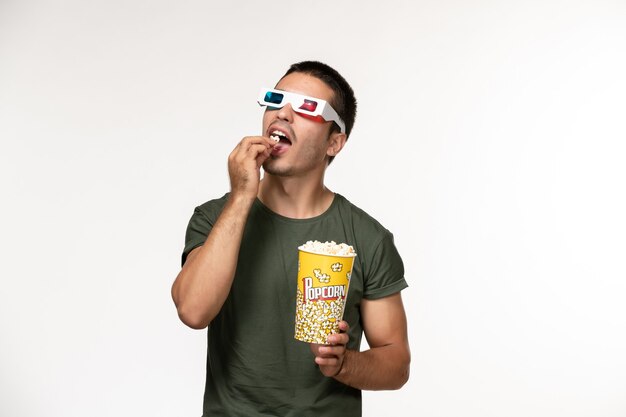 Front view young male in green t-shirt holding popcorn in d sunglasses on white desk film lonely cinema male movies