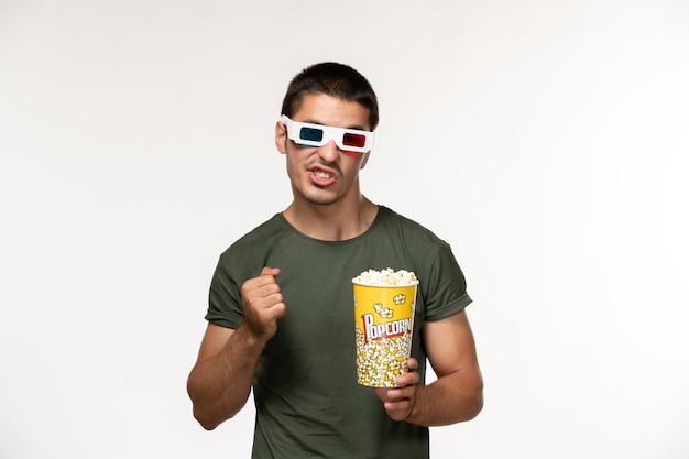 Front view young male in green t-shirt holding popcorn package in d sunglasses on white wall film lonely cinema male movie