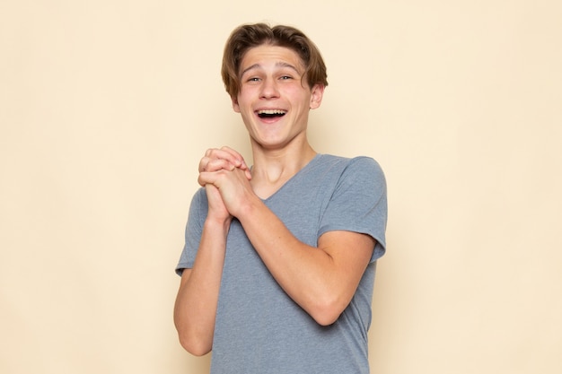 A front view young male in grey t-shirt laughing in great mood