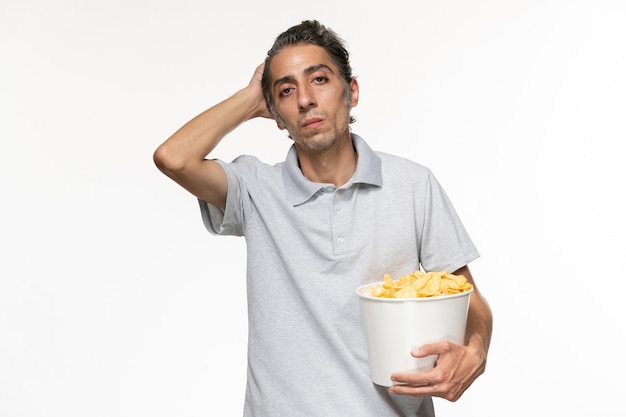 Front view young male holding basket with potato chips on a light-white surface