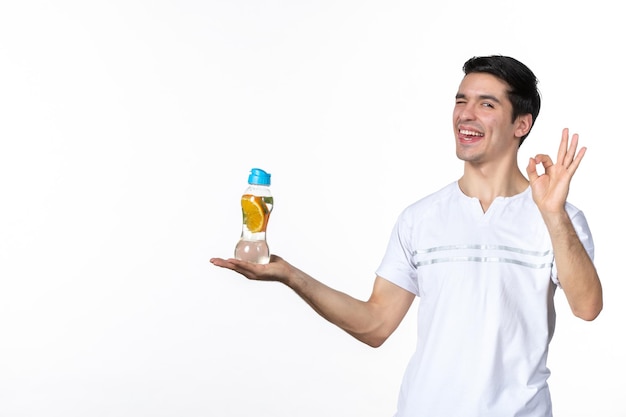 Front view young male holding bottle of lemonade on white background juice fresh drink skin fruit horizontal ice human soda liquid