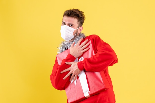 Free photo front view young male holding christmas present