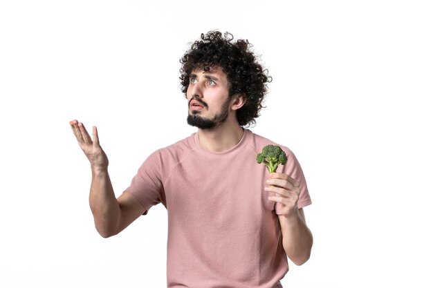 Front view young male holding little green broccoli on white background body health diet horizontal human weight vegetable salad