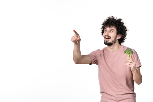 Front view young male holding little green broccoli on white background body horizontal vegetables diet health salad weight human