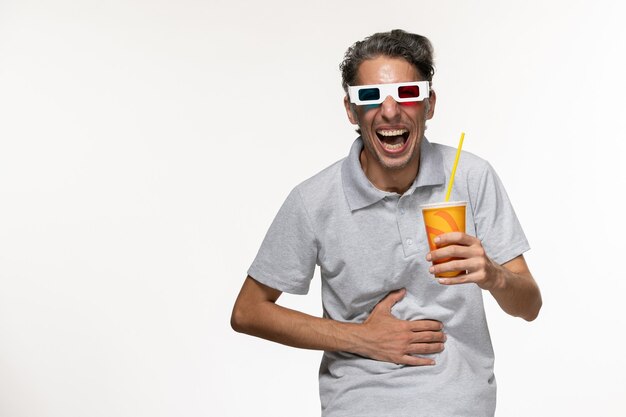 Front view young male holding soda in d sunglasses on light white wall remote movie enjoyment lonely