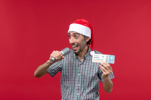 Front view young male holding ticket with mic on red floor holiday music emotion