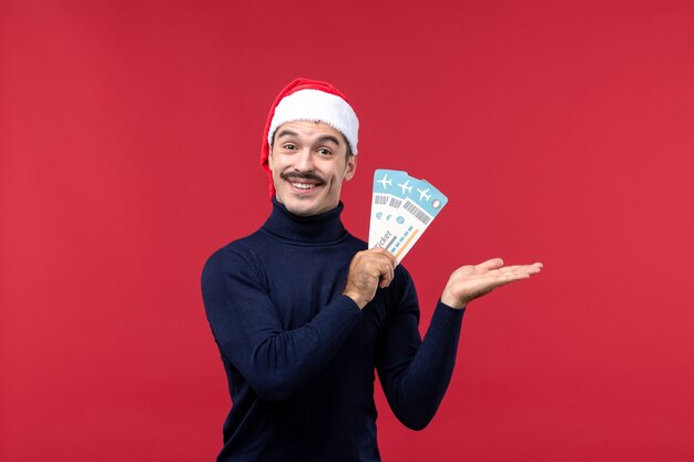 Front view young male holding tickets on red background