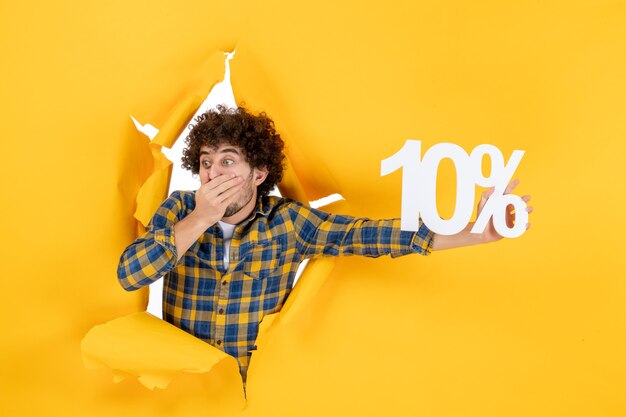 Free photo front view young male holding on a yellow background