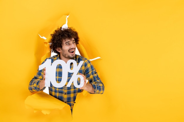 Free photo front view young male holding on a yellow background