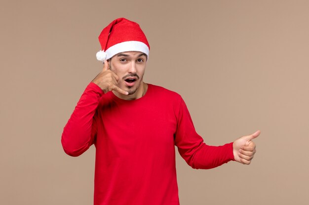 Front view young male posing on brown background christmas holiday emotion