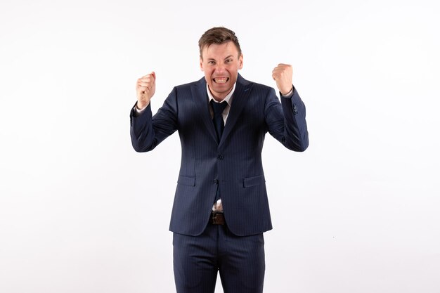 Front view young male posing with rejoicing gesture in classic strict suit on white background