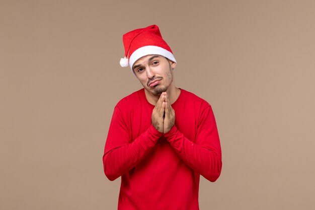 Front view young male praying with excited face on brown background christmas emotion holiday