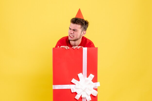 Front view young male in red shirt inside present box