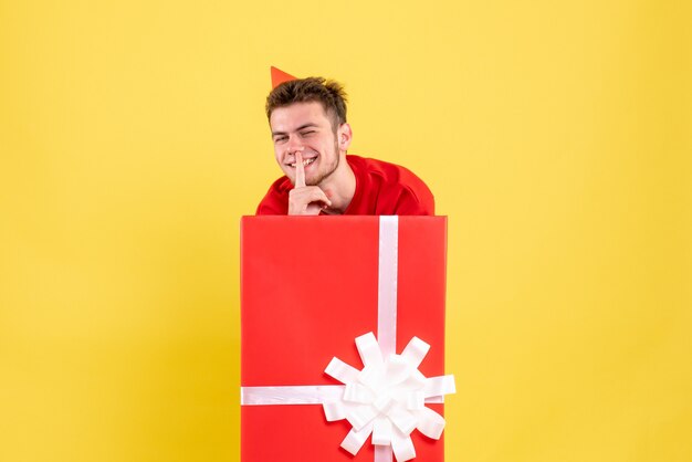 Front view young male in red shirt inside present box