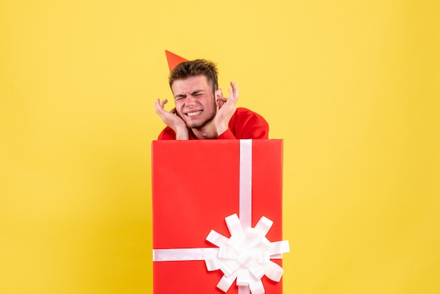 Front view young male in red shirt inside present box