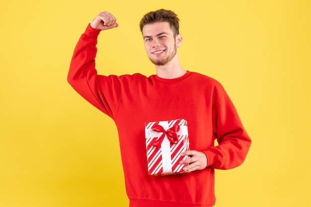 Front view young male in red shirt with christmas present