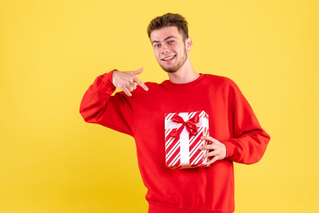 Front view young male in red shirt with christmas present