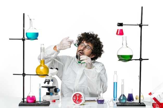 Free photo front view young male scientist in special suit working with injection and solution on white wall