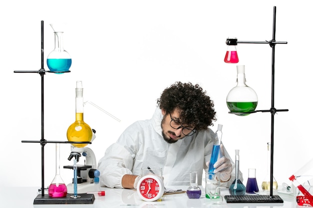 Free photo front view young male scientist in white special suit holding blue solution