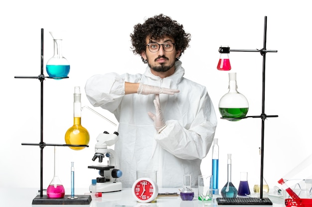 Free photo front view young male scientist in white special suit showing t sign on white wall science covid lab pandemic chemistry